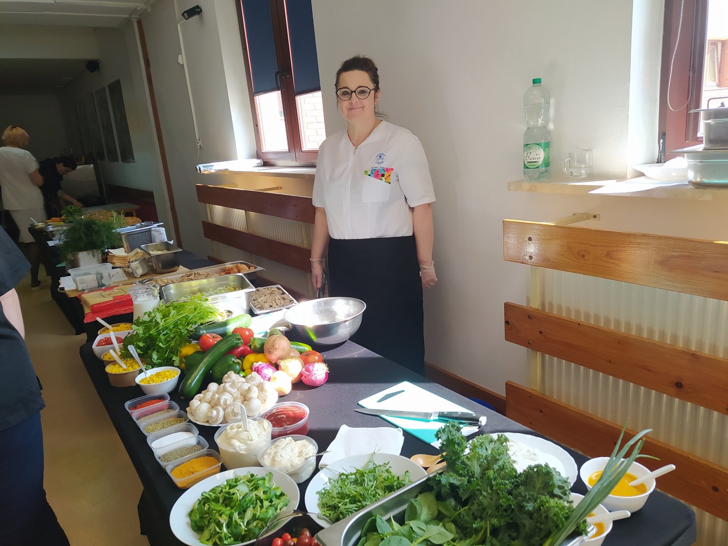 Women behind a table full of healthy plant-based food.